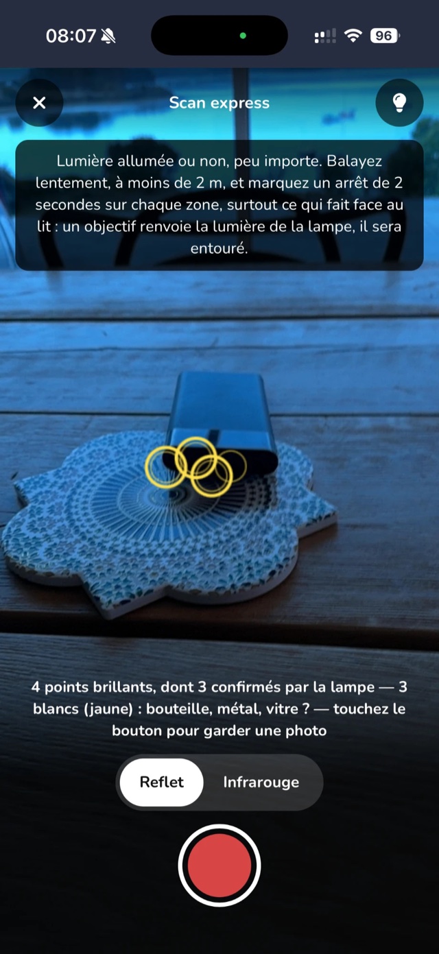 Le scanner de caméras : un petit boîtier posé sur une table, ses reflets entourés en jaune, « 4 points brillants, dont 3 confirmés par la lampe »